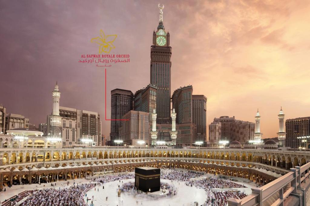 una grande folla di persone in una città con una torre dell'orologio di Al Safwah Royale Orchid Hotel a La Mecca