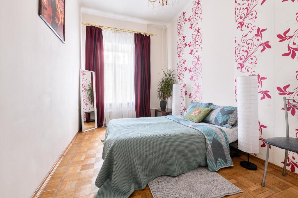 a bedroom with a bed and a table and a window at Апартаменты у Невского проспекта in Saint Petersburg