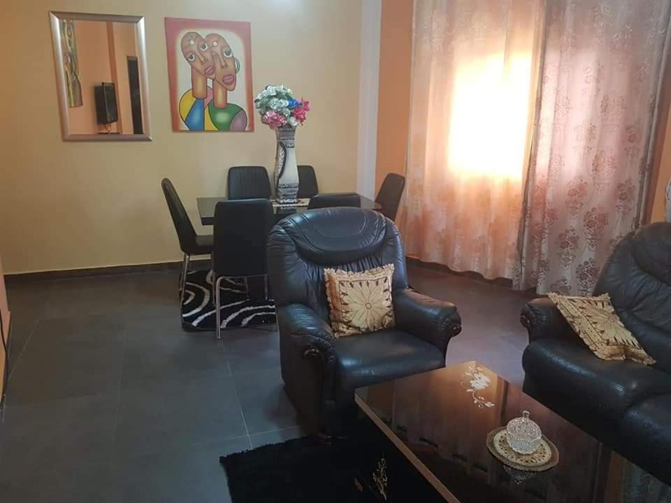 - un salon avec un canapé, des chaises et une table dans l'établissement LE MILAN ( appartements et chambres meublés ), à Douala