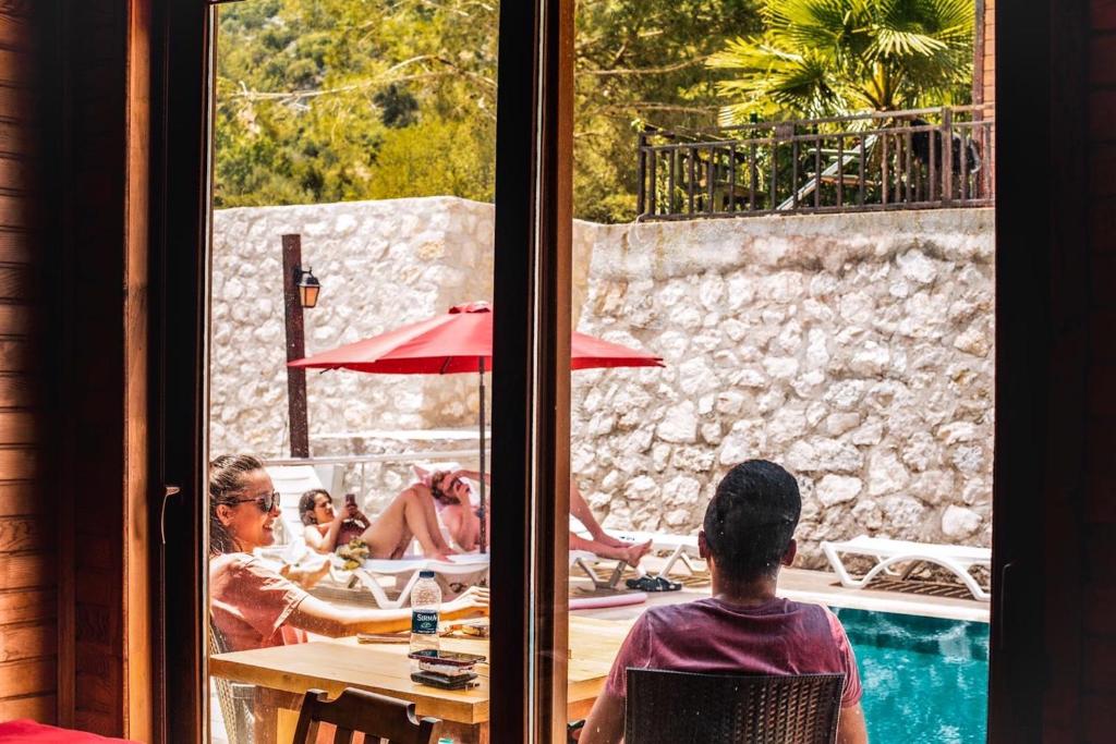 a group of people sitting at a table near a pool at 7 Green Adrasan in Adrasan