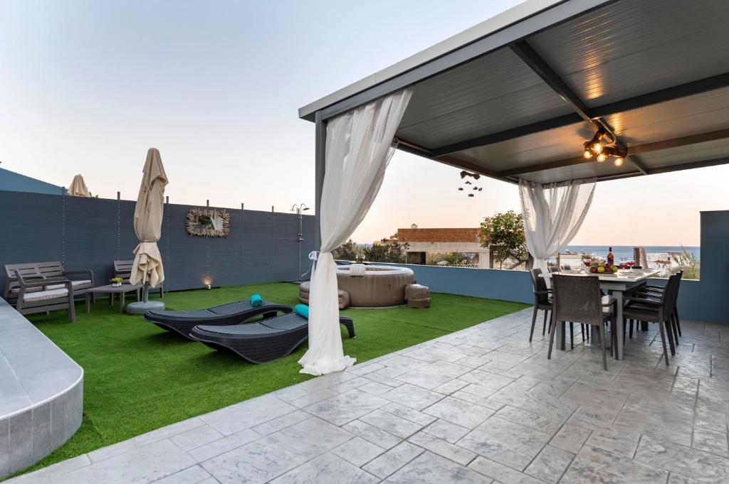 a patio with a hammock and a table and chairs at Royal Luxury Studios in Archangelos