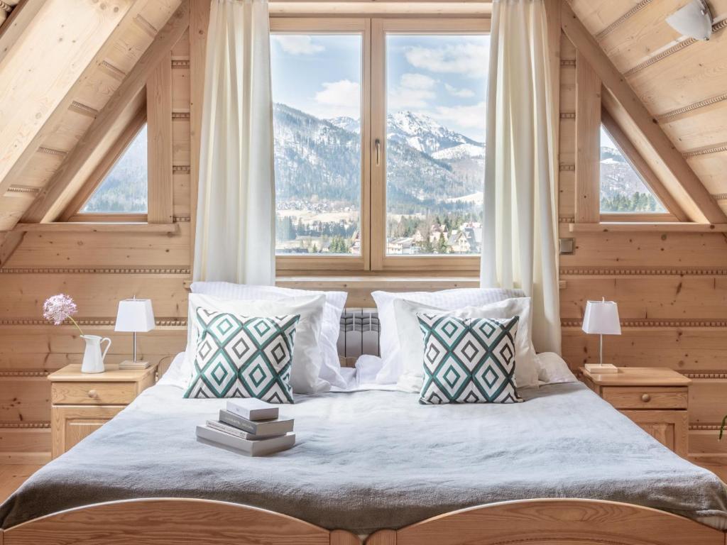 a bedroom with a bed with a large window at Wierchowa Chata in Kościelisko