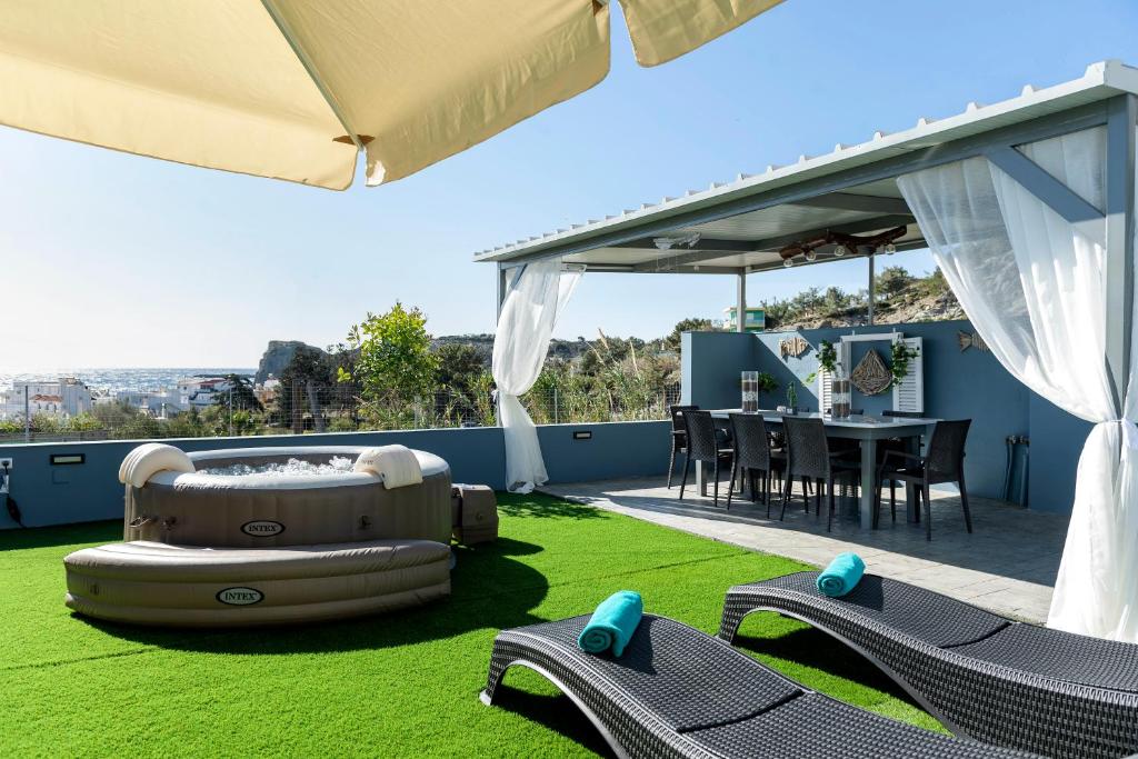 d'une terrasse avec une table et des chaises sur gazon. dans l'établissement Royal Luxury Studios, à Archangelos