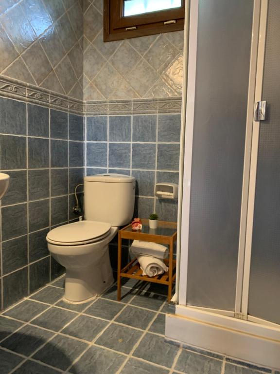 a bathroom with a toilet and a tiled floor at El Portiellu in Cabielles