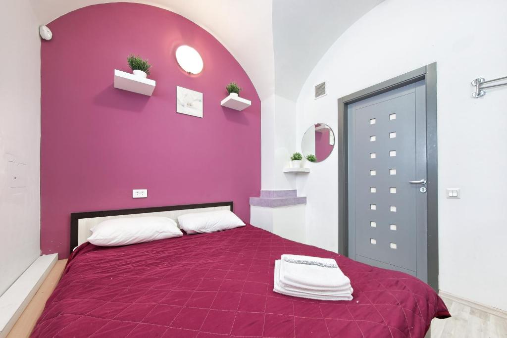 a purple bedroom with a bed with a purple wall at Guest House Prosto in Saint Petersburg
