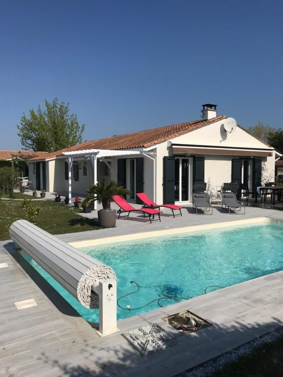 a villa with a swimming pool in front of a house at La Pépinière in Saint-Sulpice-et-Cameyrac