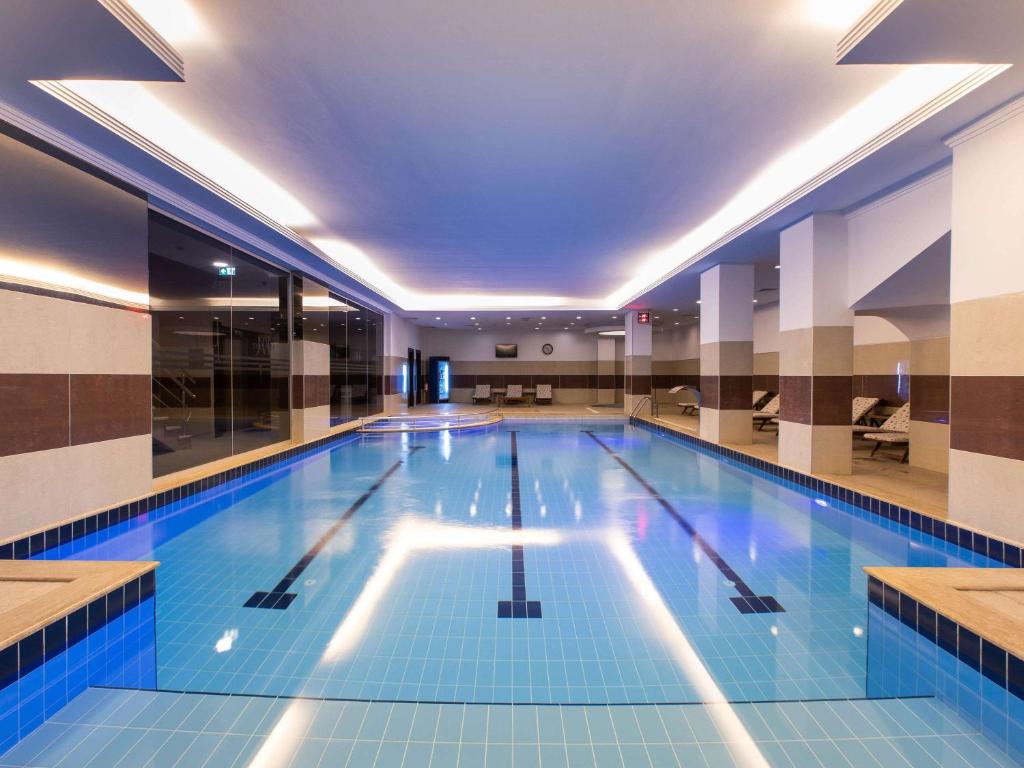 a large swimming pool in a building at Mercure Istanbul Bakirkoy in Istanbul