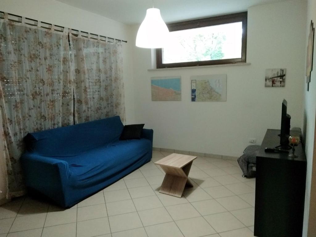 salon z niebieską kanapą i oknem w obiekcie Appartamento La Bonifica w mieście Pescara