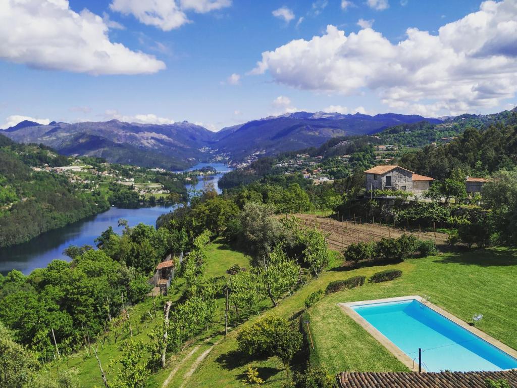 uma vista aérea de uma casa com uma piscina e um rio em Quinta De Calvelos em Vieira do Minho