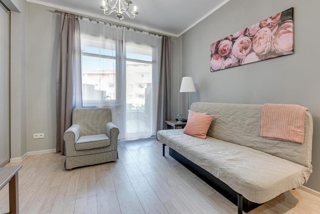 a living room with a couch and a chair at Grand Apartments - Neptun Park. in Gdańsk