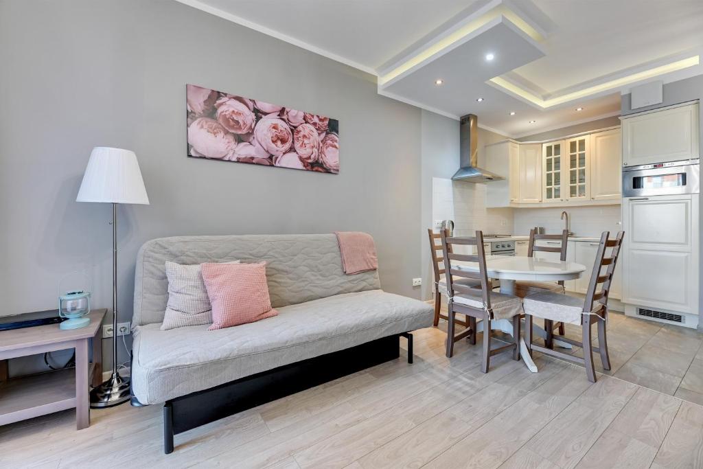 a living room with a couch and a table at Grand Apartments - Neptun Park. in Gdańsk