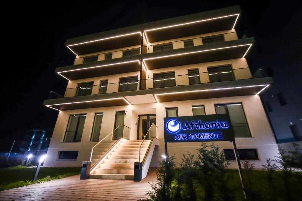 budynek z znakiem przed nim w nocy w obiekcie Afthonia Apartamente Mamaia Nord w mieście Năvodari