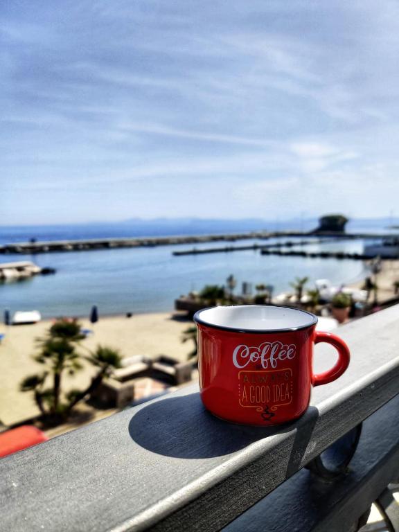 a cocacola coffee cup sitting on a railing overlooking the beach at Casa Vacanze Da Serena in Lacco Ameno