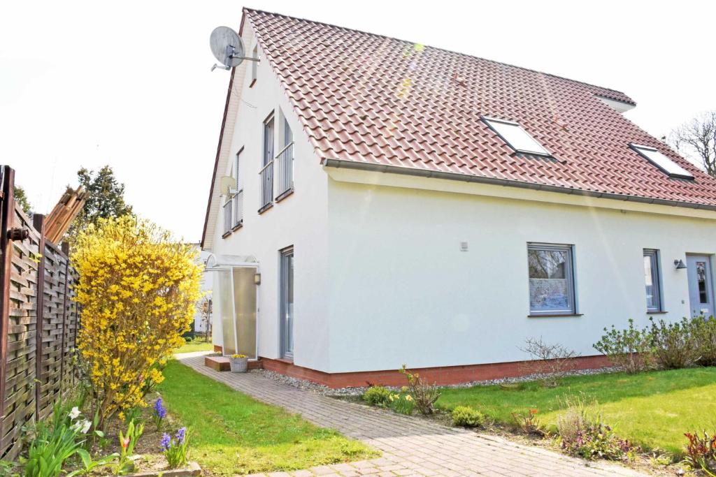 Casa blanca con techo rojo en DEB 041 Ferienwohnung am Kurpark A, en Altefähr