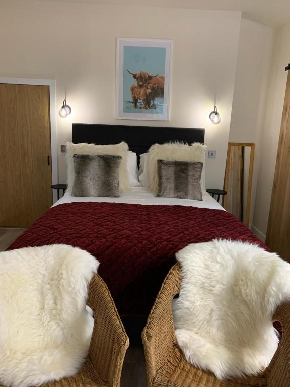 a bedroom with a large bed with two white cushions at Pear Tree Cottage in Cullen