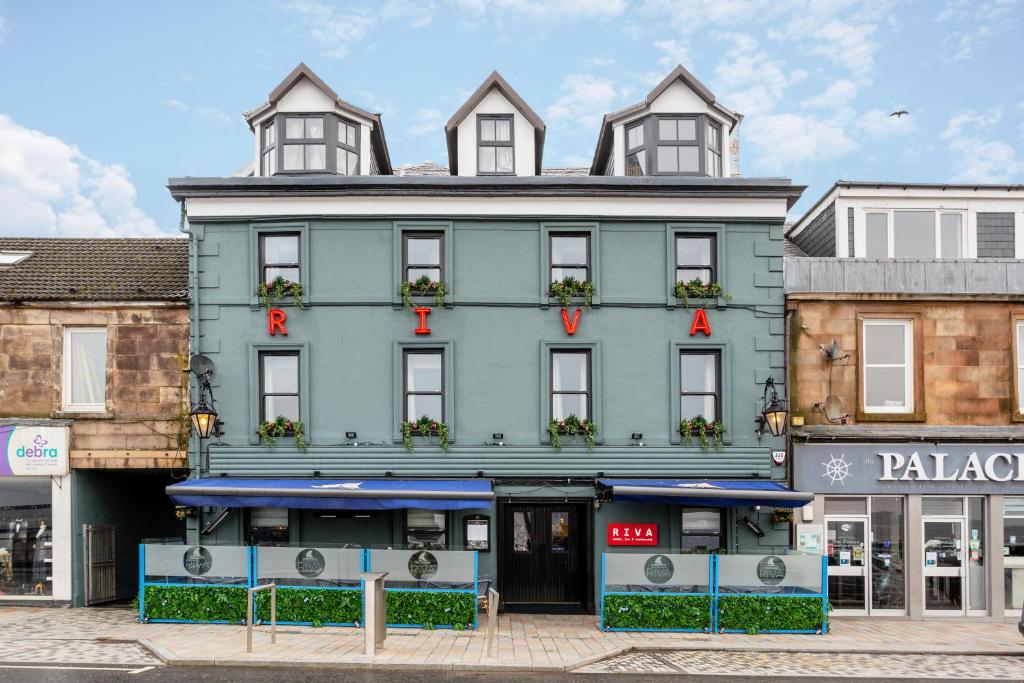 a large blue building with a store in front of it at Riva Boutique Hotel in Helensburgh