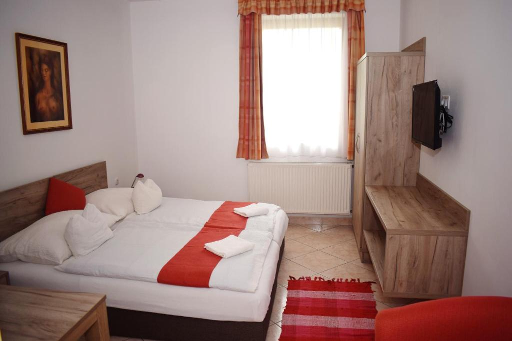 a bedroom with a bed and a window at Varga Apartmanház in Zalakaros