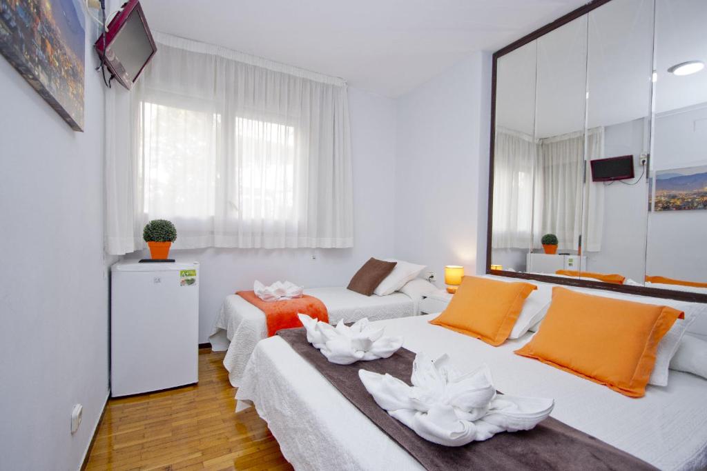 a white room with two beds and a couch at Barcelona City Seven Hostal in Barcelona