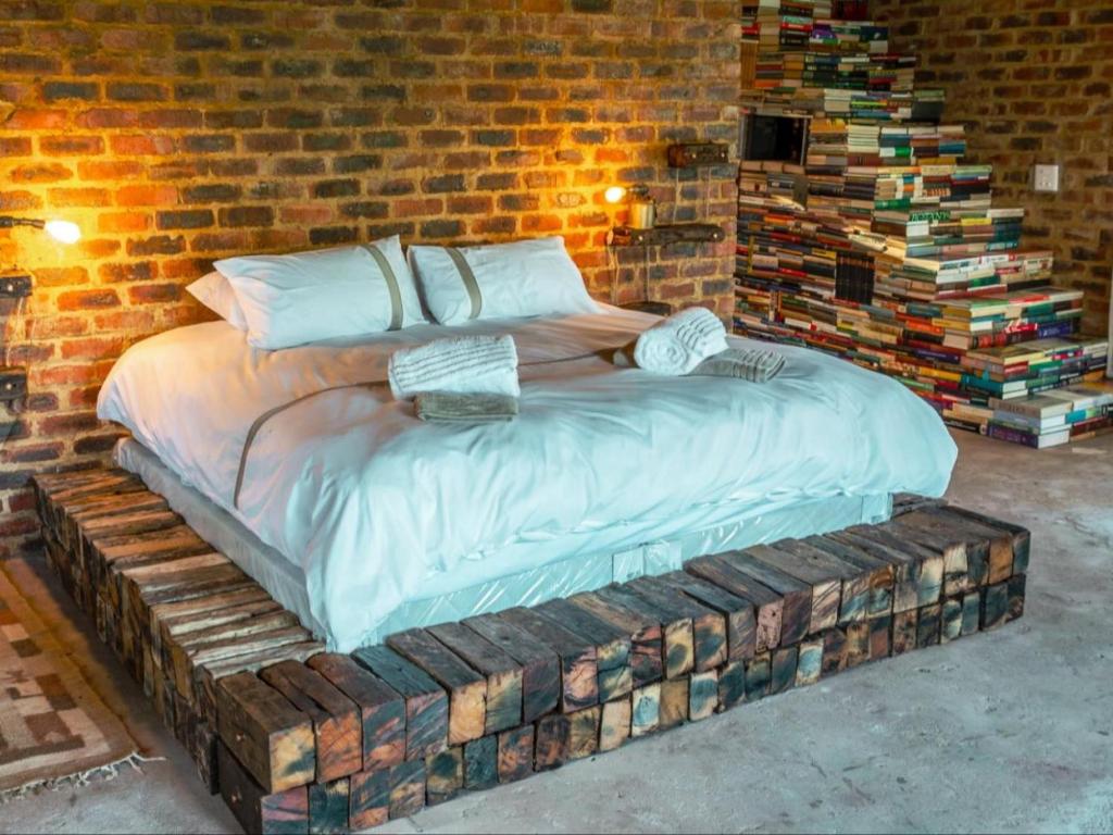 Cama en habitación con pared de ladrillo en The Ancient Copper Shed, en Potchefstroom