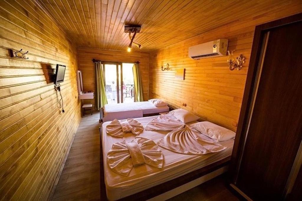 a bedroom with two beds in a wooden room at 7 Green Adrasan in Adrasan