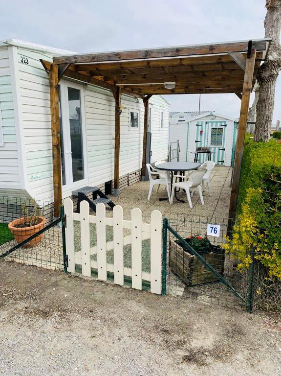 a patio with a table and a fence at Mobil-home 4 personnes 400m de la mer in Berck-sur-Mer