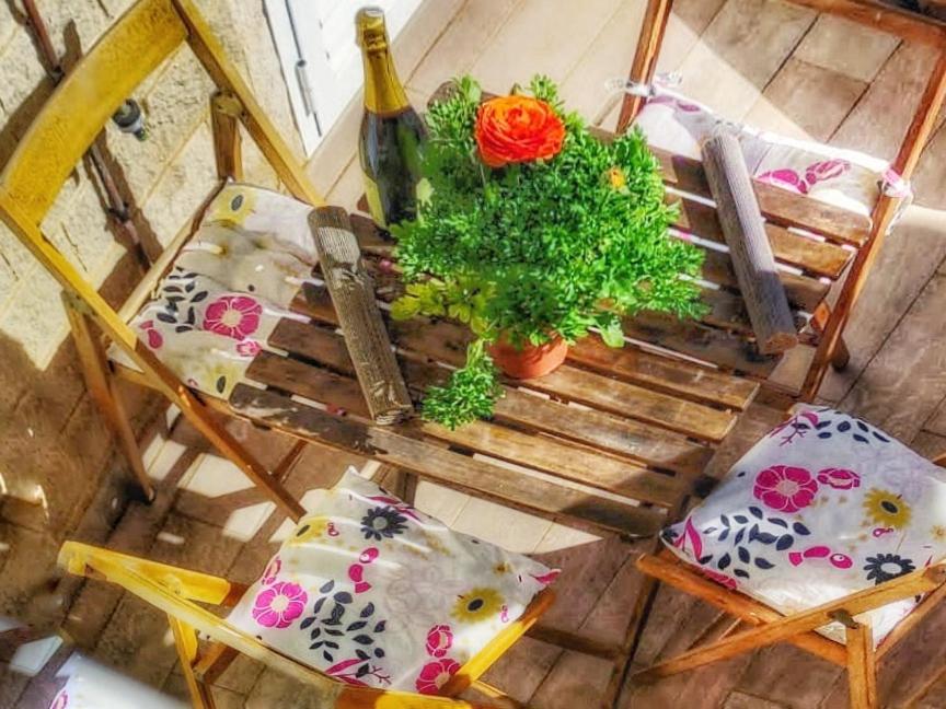 einen Tisch und Stühle mit Kissen und eine Flasche Wein in der Unterkunft Bungalow soleado a 100 metros de La Playa in La Mata