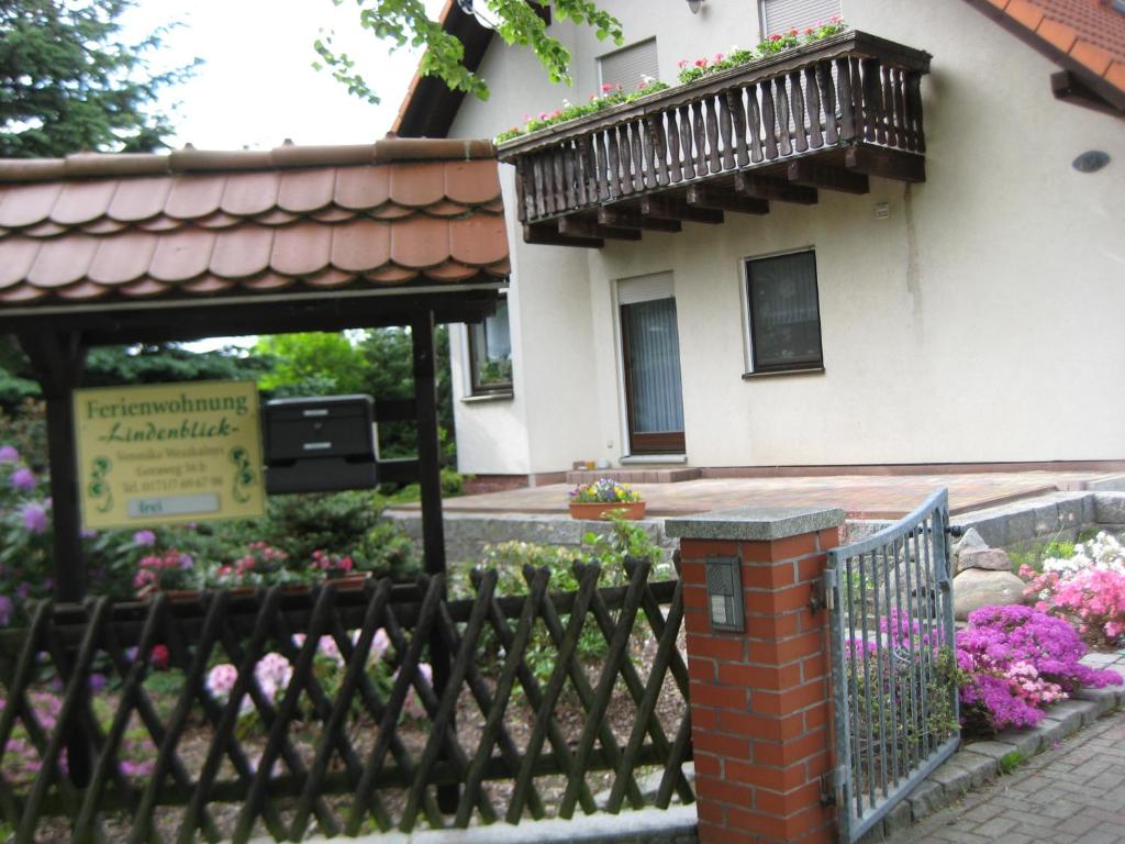 ein schwarzer Zaun vor einem Gebäude mit Blumen in der Unterkunft Ferienwohnung "Lindenblick" in Gablenz