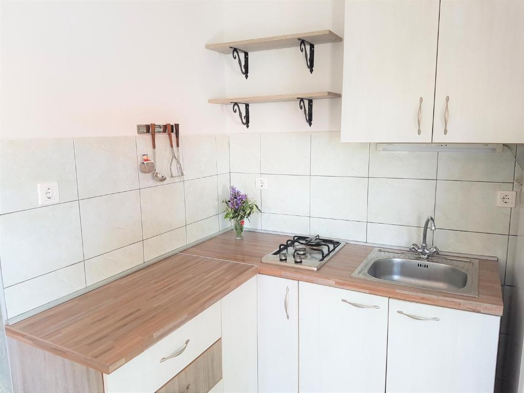 kuchnia z białymi szafkami i zlewem w obiekcie Kornati - Apartments & Stone cottage w mieście Kornati
