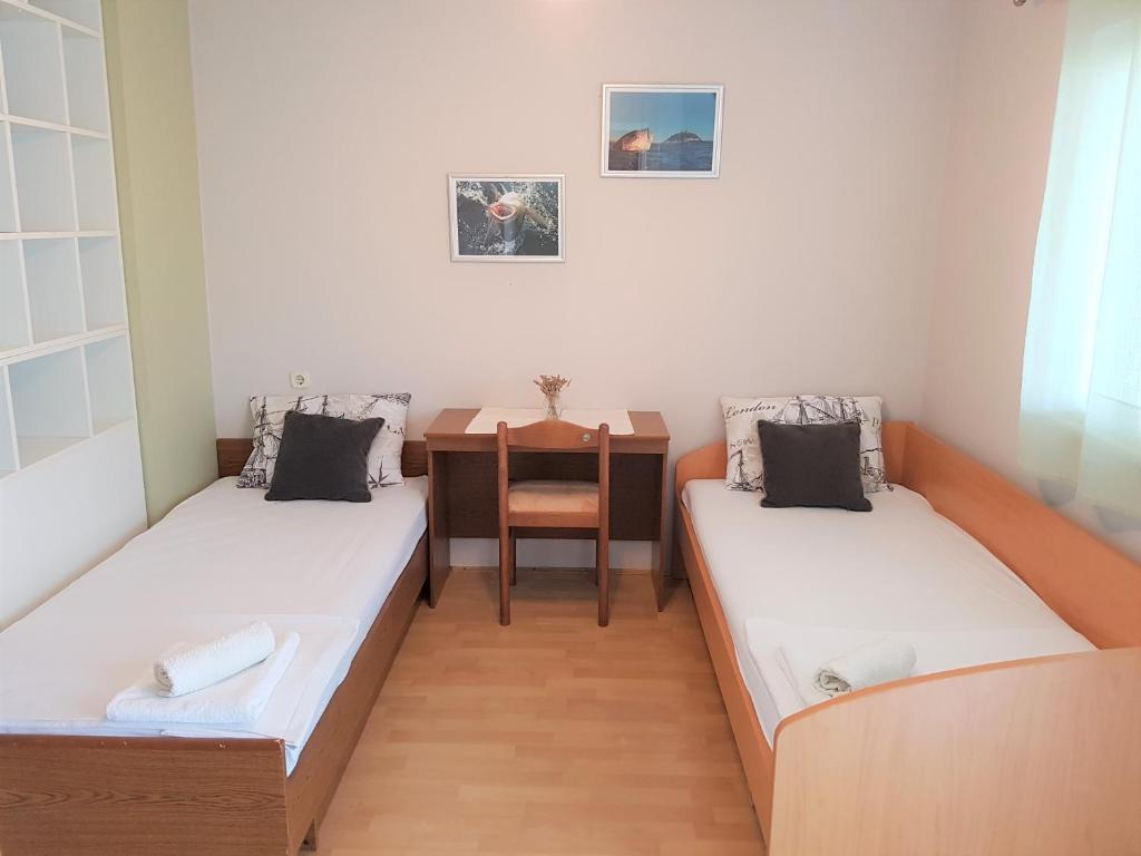 2 łóżka w małym pokoju ze stołem w obiekcie Kornati - Apartments & Stone cottage w mieście Kornati