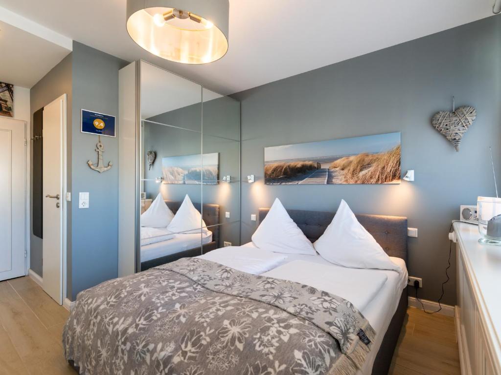 een slaapkamer met een bed en een grote spiegel bij City Blick in Westerland