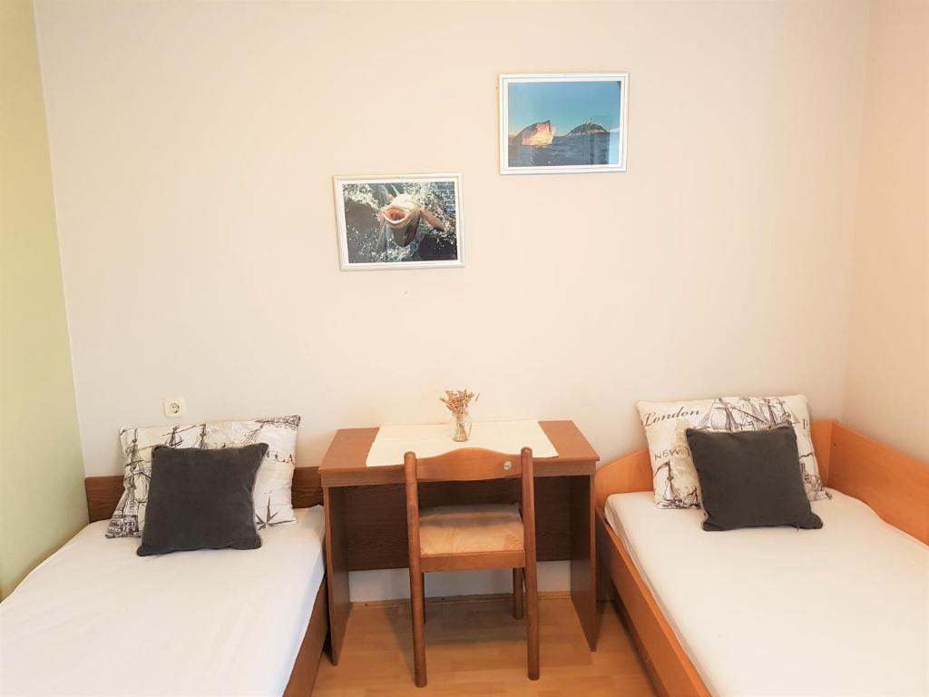 Pokój z 2 łóżkami, stołem i biurkiem w obiekcie Kornati - Apartments & Stone cottage w mieście Kornati