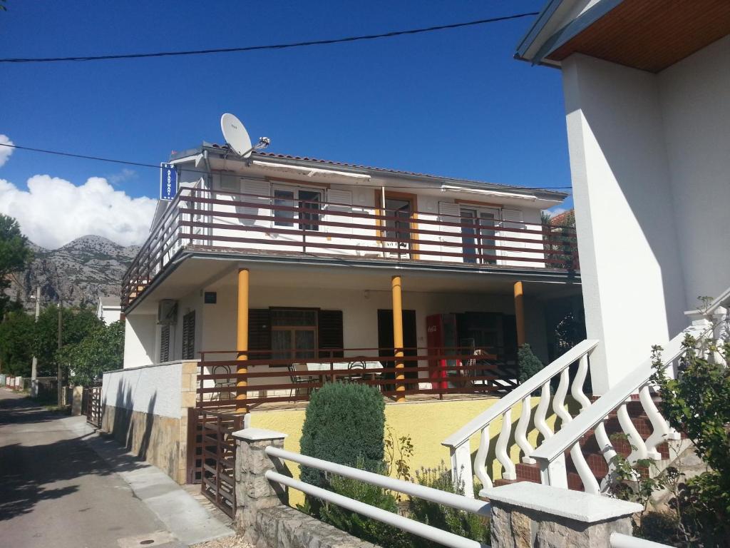 una casa con un balcón en el lateral. en Apartments L.Z. en Starigrad-Paklenica