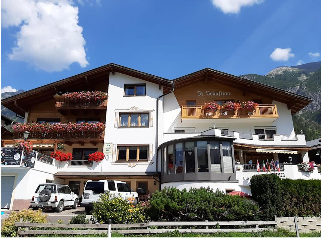 um edifício com carros estacionados em frente em Appartement Pension St. Sebastian em Pettneu am Arlberg