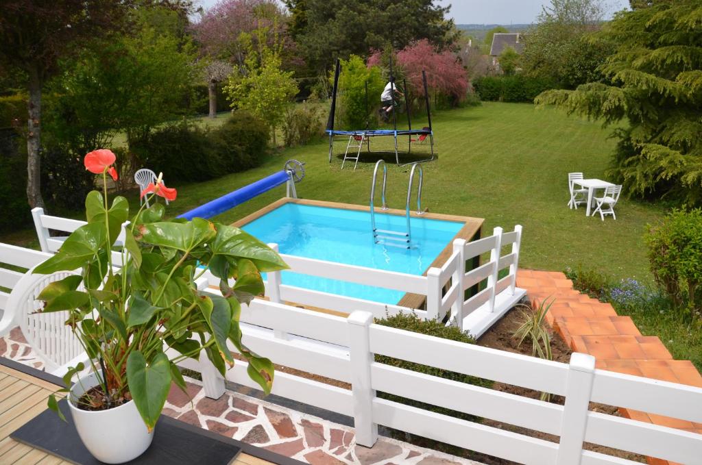 a pool in a yard with a white fence at JO 2024 Villa avec piscine proche des épreuves de canoë et aviron, de Disneyland et de Paris in Saint-Thibault-des-Vignes