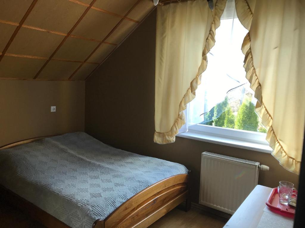 Habitación pequeña con cama y ventana en Nad Sowiogorskim Potokiem, en Jugów
