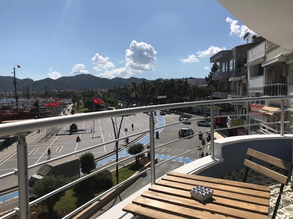 a balcony with a wooden bench and a street at Trea Homes Marina Suites in Marmaris