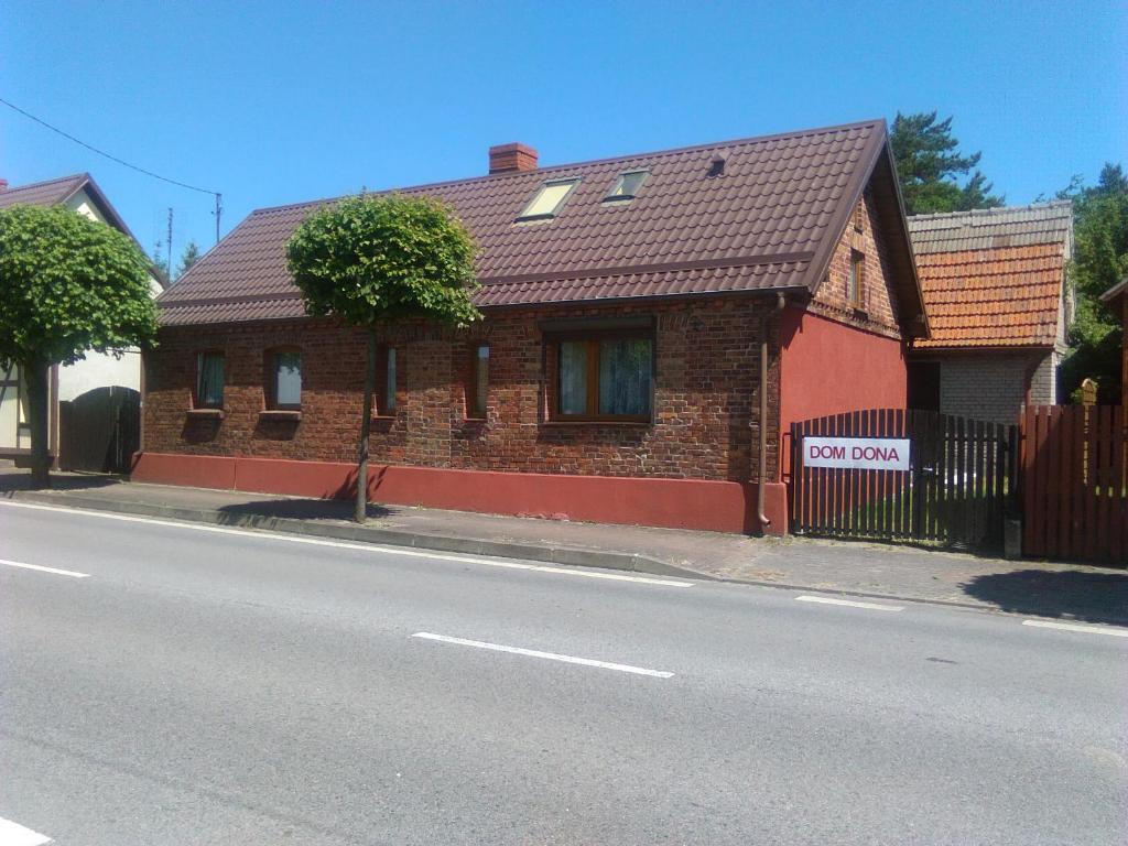 a brick house on the side of a street at Dom Dona Kuźnica - Półwysep Helski in Kuźnica