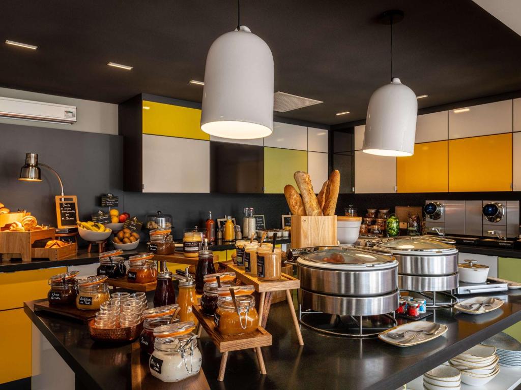 a kitchen with a counter with pots and pans at Mercure Valence in Valence