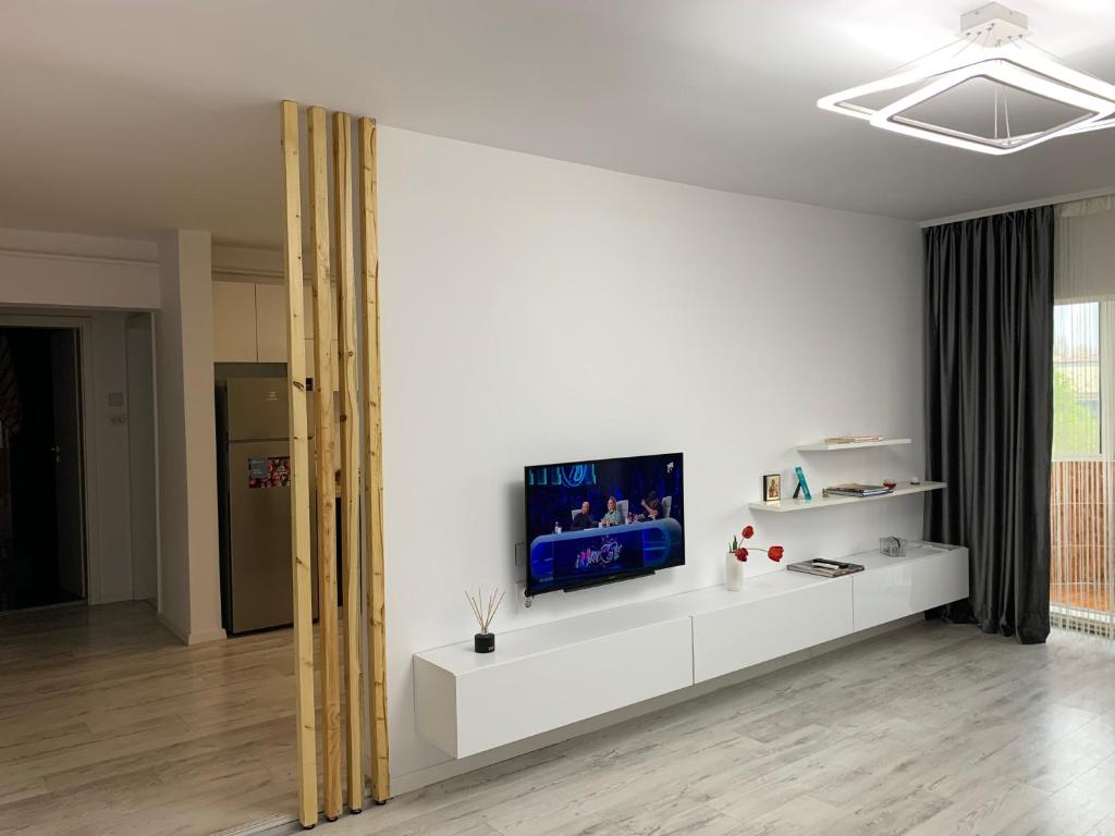 ein Wohnzimmer mit einem TV an einer weißen Wand in der Unterkunft Gabriel's Apartment in Constanţa