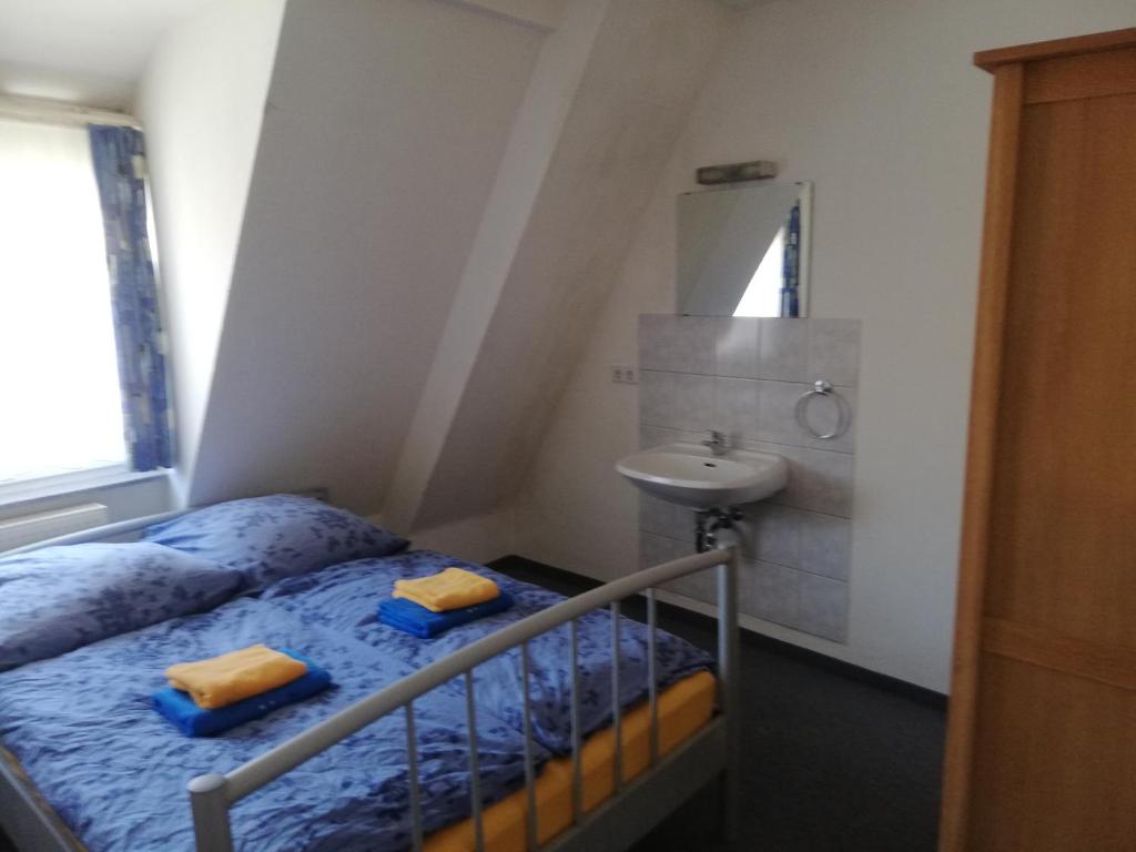 a small bedroom with a bed and a sink at Gastehaus Heigeleshof in Ulm