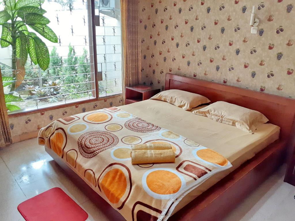 a bed in a bedroom with a large window at GIO Guesthouse Bogor in Bogor