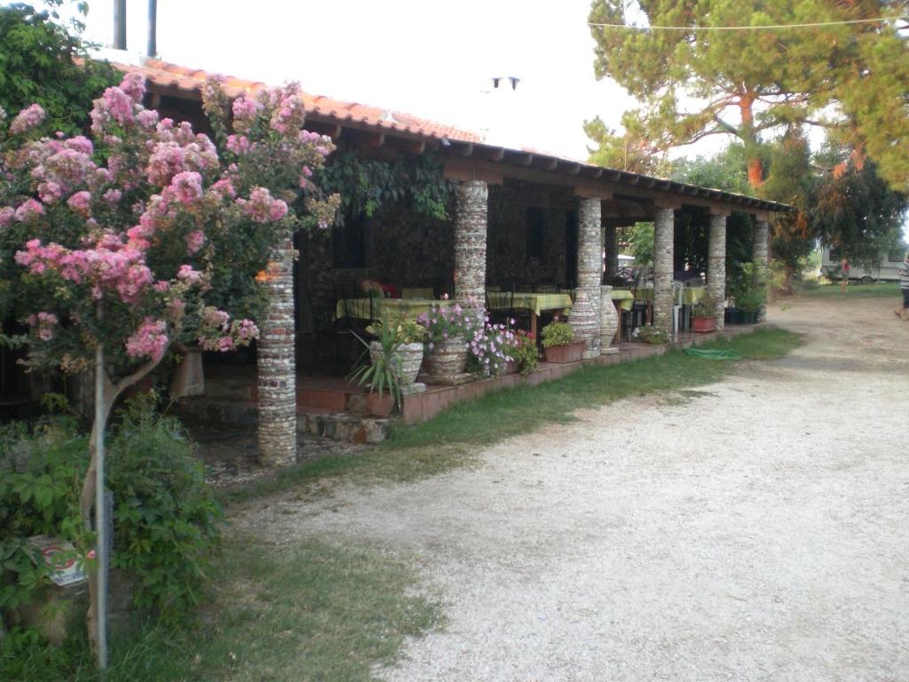 a pavilion with pink flowers in a garden at Eleni Rooms Develiki in Ierissos