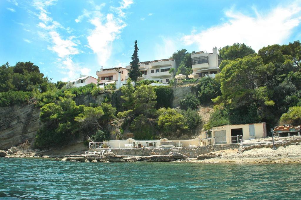 a house on top of a hill next to the water at ALKYONI in Skala
