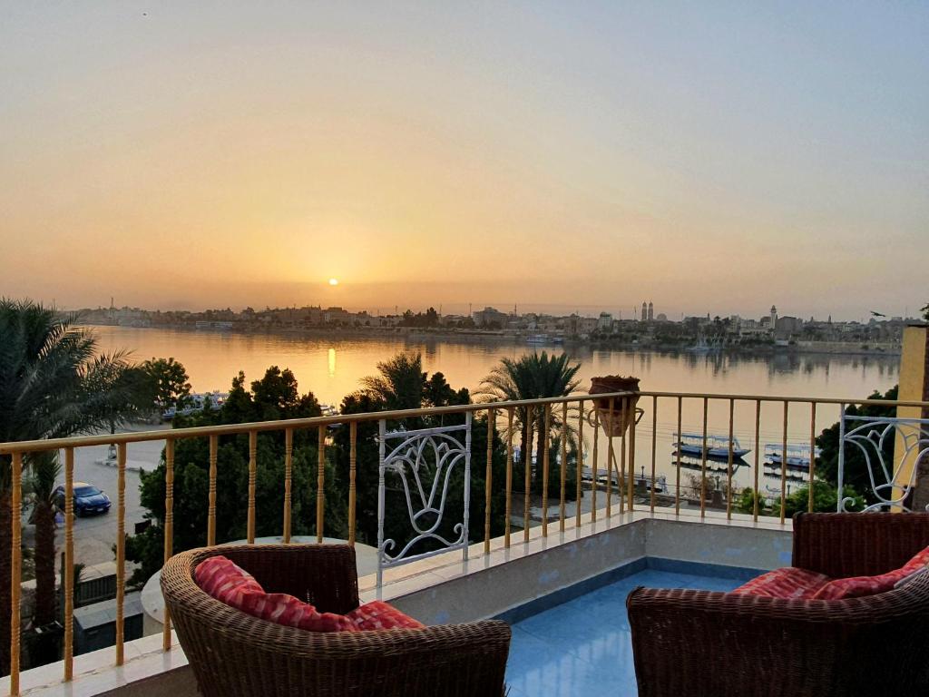 uma varanda com cadeiras e vista para um rio em Spring Hotel Luxor em Luxor