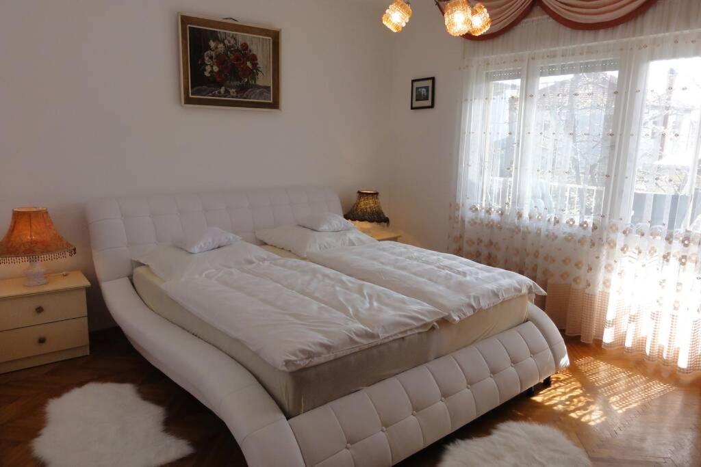 a large white bed in a room with windows at Croatia Zadar Borik big Family Apartment with garden view Number 6 in Zadar