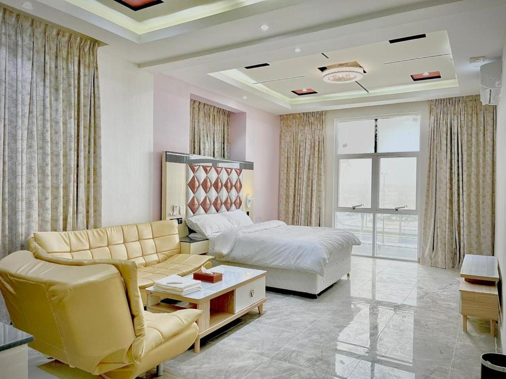 a bedroom with a bed and a bed and a couch at Asian Hotel in Duqm