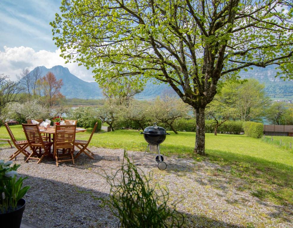 a barbecue grill in a garden with a table and chairs at Cosy Chalet 50m du lac, une exclusivité LLA Selections by Location Lac Annecy in Doussard