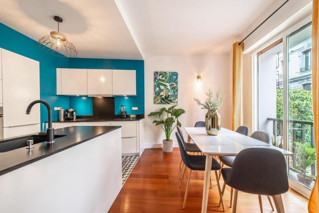 a kitchen with blue walls and a table and chairs at L'étoile annécienne - 3 rooms 80 square meter - Terrace in Annecy