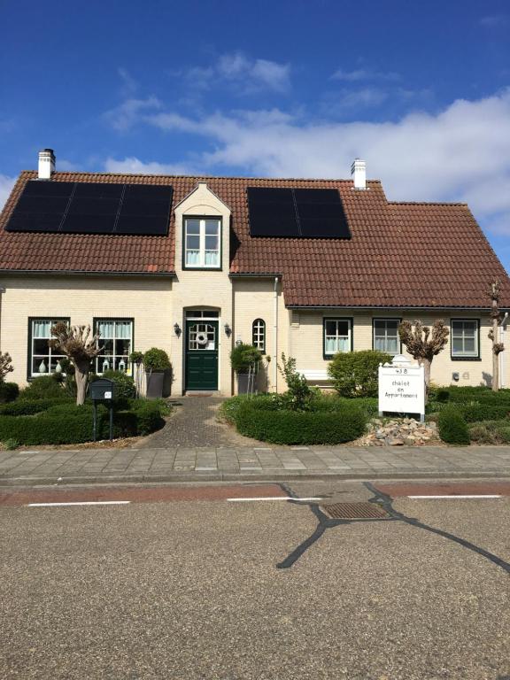 uma casa com painéis solares no telhado em Chalet or Apartment nearby Roermond Outlet em Stevensweert