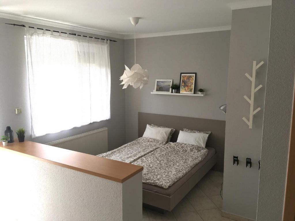 een kleine slaapkamer met een bed en een raam bij Balatonlelle Apartmanház in Balatonlelle